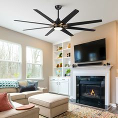 a living room with a fire place and ceiling fan