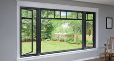 an empty room with large windows overlooking the yard