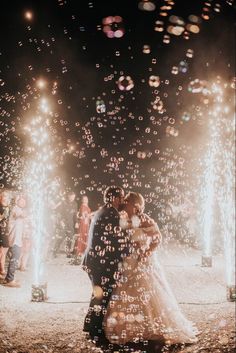 a bride and groom kissing in front of fireworks