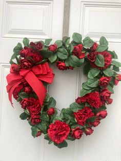 a wreath with red flowers and green leaves