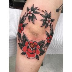 a woman's leg with flowers and leaves on it, in the shape of a circle