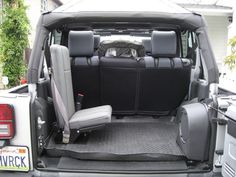 the back end of a vehicle with seats folded up and luggage in the trunk area