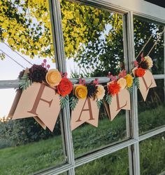 a window decorated with paper flowers and the word fear hanging from it's side