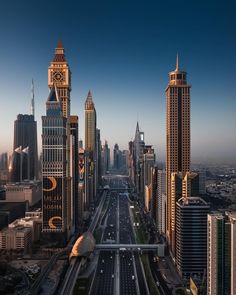 an aerial view of a city with skyscrapers and roads in the foreground, at dusk