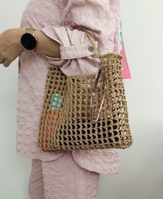 a woman in pink is holding a handbag on her left arm and the other side of her body