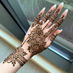 a woman's hand is decorated with hennap and intricate designs on it