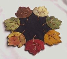 a group of leaves sitting on top of a white table next to a black circle