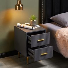 a nightstand with two drawers and a phone on it next to a bed in a bedroom