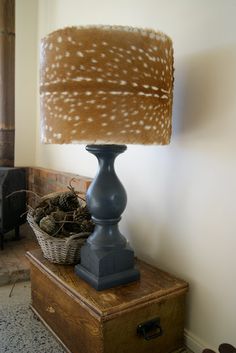 a lamp that is sitting on top of a table next to a basket with birds in it