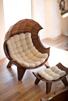 a chair and ottoman sitting on top of a hard wood floor