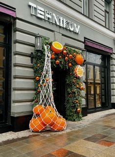 an orange display in front of the thinkum store with fruit hanging from it's sides