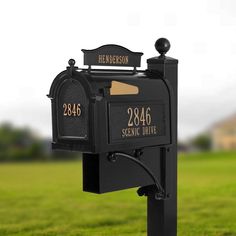 a black mailbox sitting on top of a lush green field