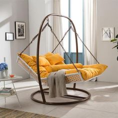 a swing chair with orange cushions in a living room