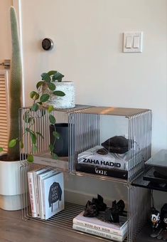 three tiered metal shelving unit with books and plants