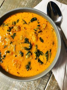 a bowl of creamy italian sauteage soup with spinach and cheese on top