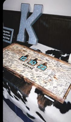 a large wooden table with writing on it in front of a k sign and other items