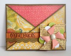 an origami pinwheel on top of a card with congratulations written in it