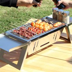 two people are preparing food on a grill outside in the grass, with beer being poured over them