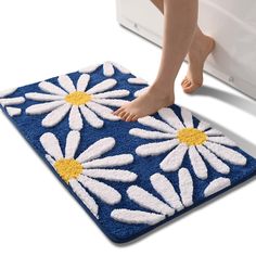 a person standing on a blue and white mat with daisies in the center, next to a washing machine