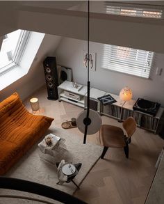 an overhead view of a living room with orange couches and white carpeted flooring