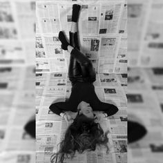 a woman laying on the ground in front of newspapers