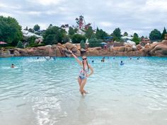 a woman in a bathing suit standing in the water at disney world's animal kingdom