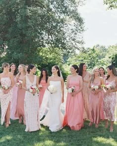 a group of women standing next to each other on top of a lush green field