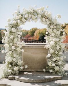 a white flowered arch on top of steps