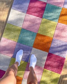 a person's feet on a multicolored rug with their toes up in the air