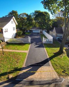 an aerial view of a residential street with houses in the background and yellow tape across the road