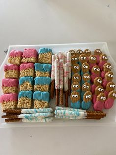 an assortment of cookies and marshmallows are arranged on a platter with candy sticks