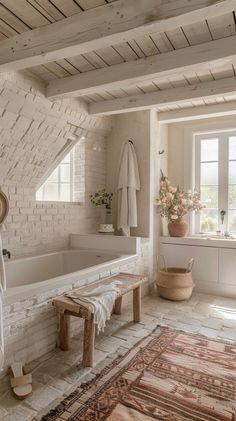 a bathroom with a large bathtub next to a window and rug on the floor