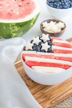 an american flag fruit bowl on a cutting board with watermelon and blueberries