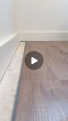 a wooden floor with a white wall in the background and a video player on it