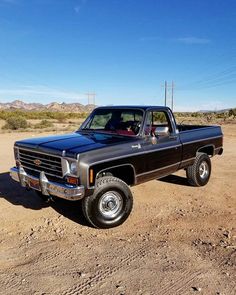 a black pickup truck parked in the desert