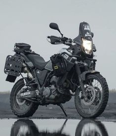 a motorcycle parked on the beach with its lights on