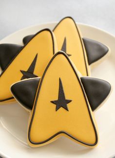 three decorated cookies sitting on top of a white plate