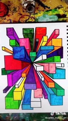 someone is holding up a drawing with colored blocks in the shape of a rainbow wheel