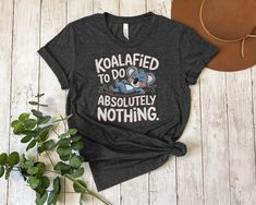 🐨 Funny Koala T-Shirt with the phrase "Koalafied to Do Absolutely Nothing". Perfect for lazy days or koala lovers 💤. This cute koala tee will bring a smile to anyone's face and is ideal for casual wear. Comfortable and stylish, show off your love for koalas with this adorable design. Great gift for friends and family too 🎁. Available in various sizes. Product Features: Fabrication: 100% Airlume combed and ring-spun cotton, 32 single 4.2 oz. (Ash - 99% Airlume combed and ring-spun cotton, 1% p Funny Koala, Cute Koala, Lazy Day, Animal Shirts, To Do, Koala, Clothing Items, Spun Cotton, Casual Wear