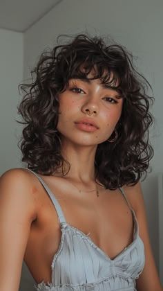 Curly haircuts are all about celebrating your texture and finding a style that complements your face shape. Curly Hair With Bangs And Glasses, 90s Wavy Haircut, Hair Cuts Short With Bangs, Thick Wavy Haircuts Medium, Short Curly Hair With Curtain Bangs, Curly Bangs Short Hair, Curly Hair Bob With Bangs, Face Framing Pieces Curly Hair, Medium Curly Hair With Bangs