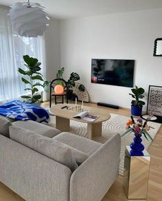 a living room filled with furniture and a flat screen tv mounted to the side of a wall