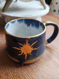 a blue and yellow cup sitting on top of a wooden table