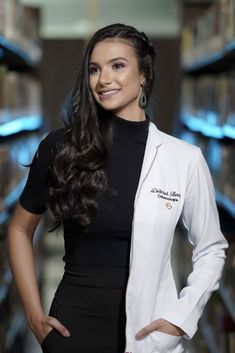 a woman in a white lab coat posing for the camera