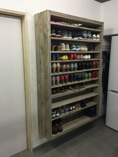 a large shoe rack in the corner of a room with several pairs of shoes on it