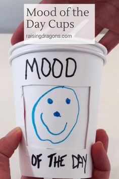 someone holding up a cup with the words mood on it