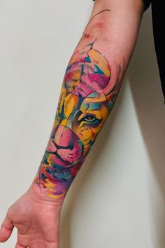 a man with a colorful tattoo on his arm holding onto a hand that has a lion face painted on it