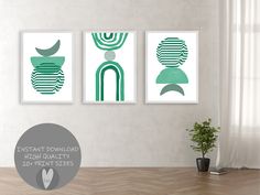 three green art prints hanging on the wall above a wooden table with a potted plant