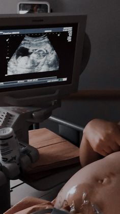 a person laying in bed with an x - ray image on the monitor screen and headphones to their ear