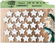 a bunch of white wooden stars with names on them sitting next to a green ribbon