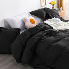 a bed with black sheets and white pillows